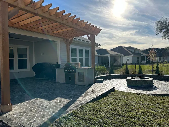 Cedar pergola over a herringbone paver patio with built-in outdoor kitchen and grill in St. Johns County FL