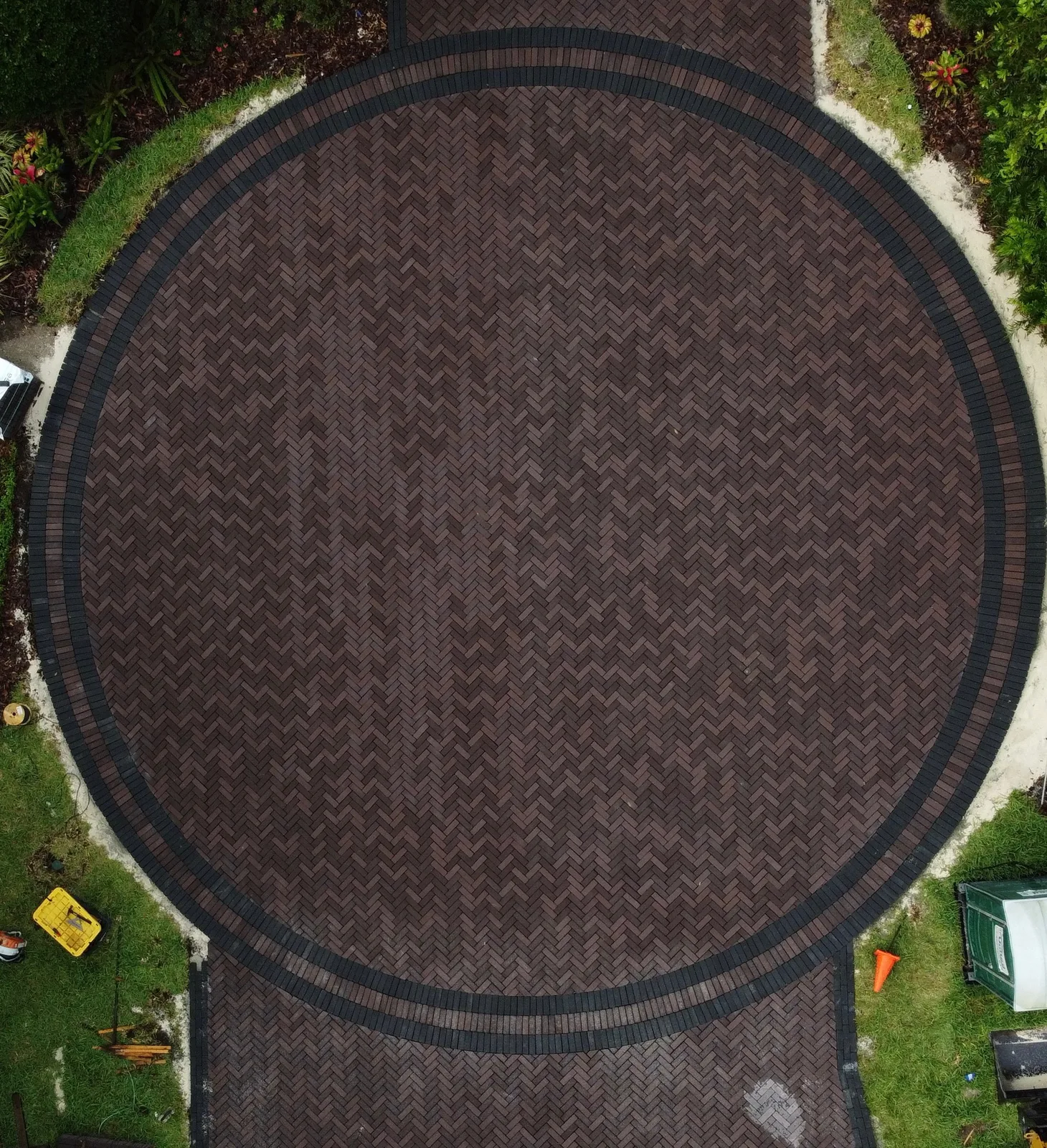 Aerial view of a circular dark herringbone paver driveway with a black double border in St. Augustine FL